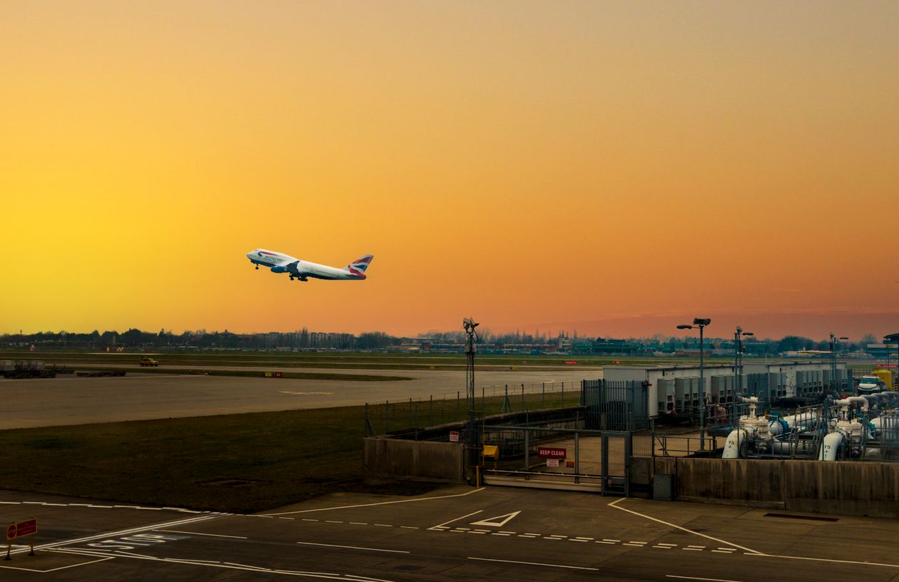 A British Airways jet climbing away from Heathrow at sunset